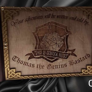 Könnte beinhalten: Ein dreiteiliges Spielbrett aus Holz mit goldener Umrandung und einem keltischen Knotenmuster. Das mittlere Feld zeigt einen Würfel mit dem Text "This is gonna hurt" und "Thomas the Genius Bastard". Das linke Feld trägt den Text "The Weaver of Fate" und ein stilisiertes Auge. Das rechte Feld trägt den Text "The Gatherer of Souls" und einen Wolfskopf.