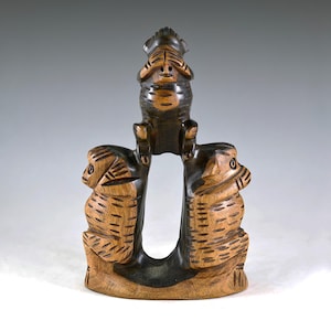 Puede incluir: Tres monos de madera tallados en un estilo tradicional. El mono del medio se tapa los ojos, mientras que los monos a cada lado se tapan las orejas y la boca. Los monos son marrones y negros.