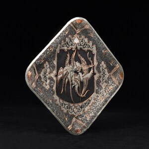 May include: A silver and copper square tray with an intricate design of birds and floral patterns. The tray has a textured surface and a black background.