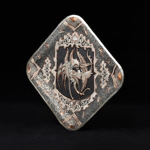 May include: A silver and copper square-shaped decorative plate with an intricate design of birds and floral patterns.