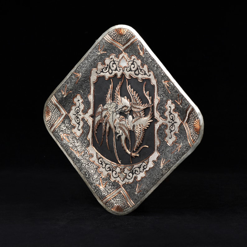 May include: A silver and copper square-shaped decorative plate with an intricate design of birds and floral patterns.