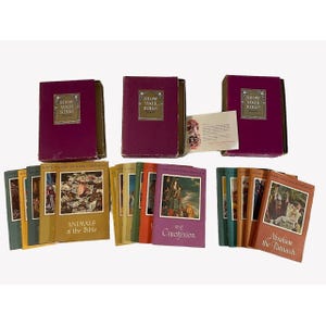 May include: A set of 18 small, colorful books with illustrations and titles like "Animals of the Bible" and "The Crucifixion". The books are in three burgundy boxes with gold lettering that reads "Know Your Bible".