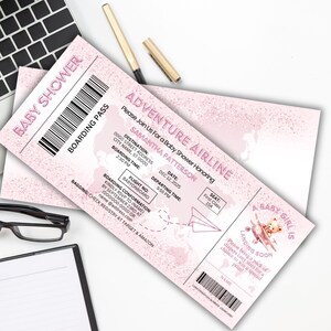 May include: Pink baby shower boarding pass with the text "Baby Shower" and "Adventure Airline". The invitation includes details like the honoree's name, date, time, and a teddy bear graphic. A pen and keyboard are in the background.