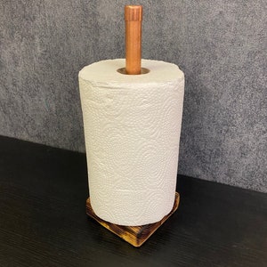 以下が含まれることがあります： 銅製の棒と白いペーパータオルのロールが付いた木製ペーパータオルホルダー。ホルダーは、素朴な焦げ付きの木材仕上げです。