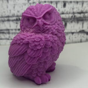 May include: Purple owl-shaped candle with detailed feathers and a white wick.