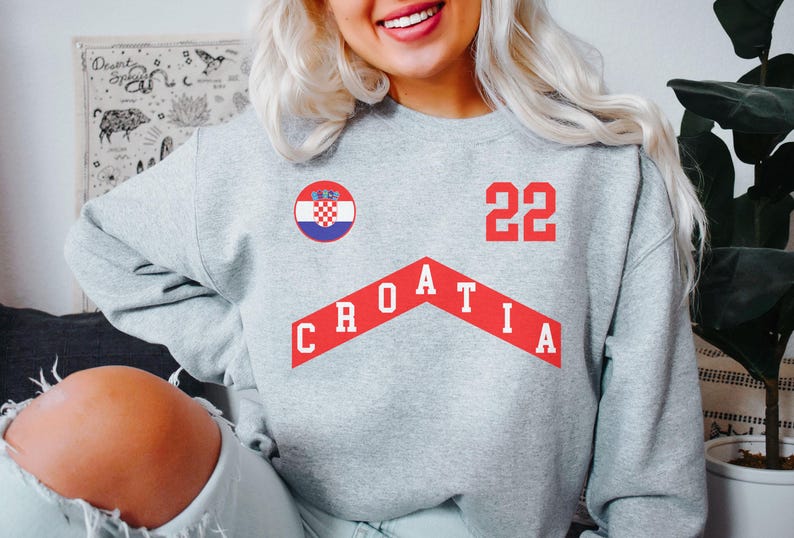 May include: Gray sweatshirt with a red Croatian flag, the word "CROATIA" in red, and the number "22" in red.