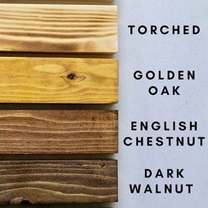 May include: Six wood samples in different shades of brown, from light to dark. The samples are labeled with the following wood types: Natural, Torched, Golden Oak, English Chestnut, Dark Walnut, and Ebony.