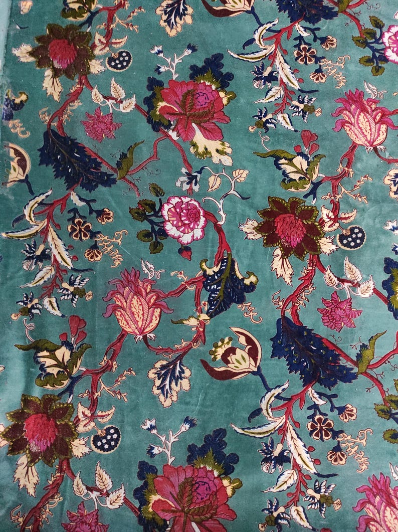 Puede incluir: Tela color turquesa con un detallado estampado floral. El dise&ntilde;o presenta grandes flores estilizadas en tonos rosa, burdeos y crema, con follaje azul oscuro y verde. El patr&oacute;n se repite en la superficie de la tela.