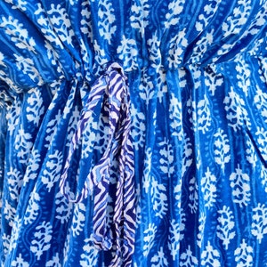 May include: A blue cotton fabric with a white floral pattern. The fabric has a drawstring tie at the waist.