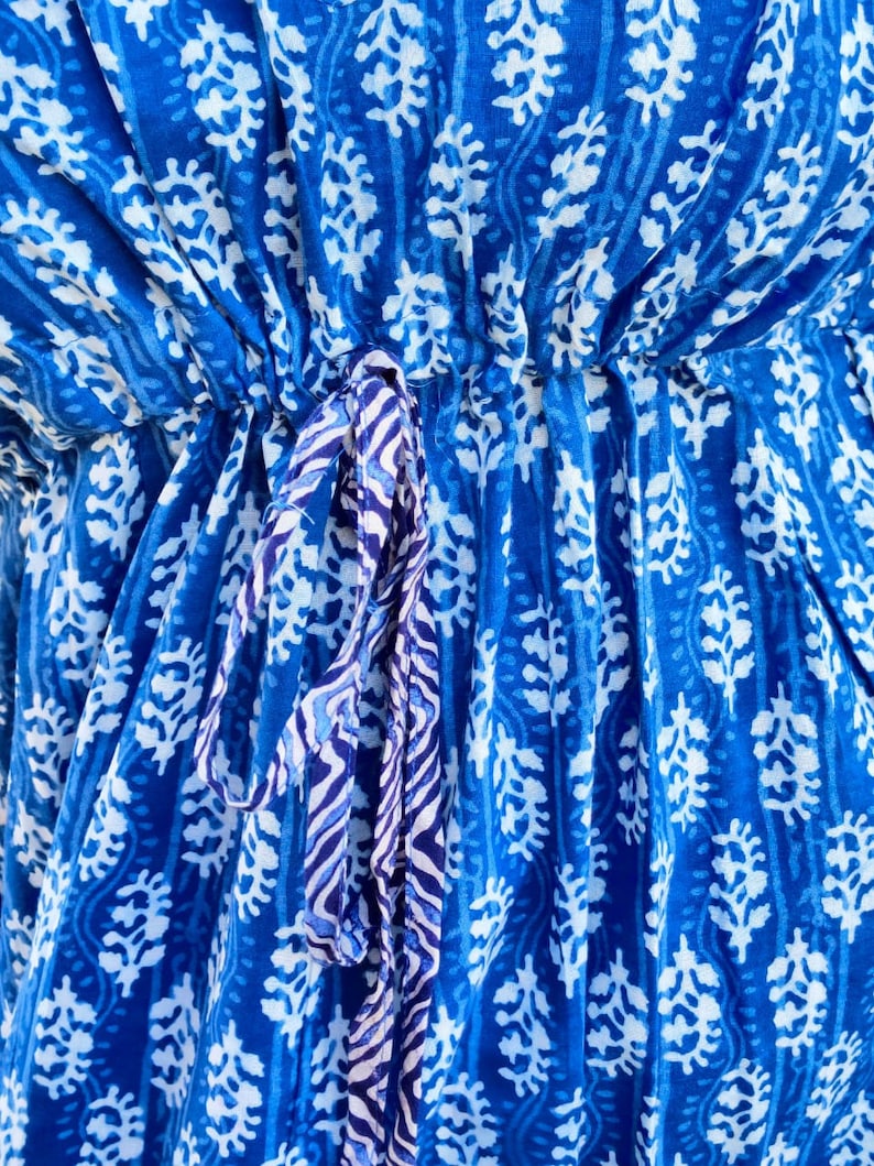 May include: A blue cotton fabric with a white floral pattern. The fabric has a drawstring tie at the waist.