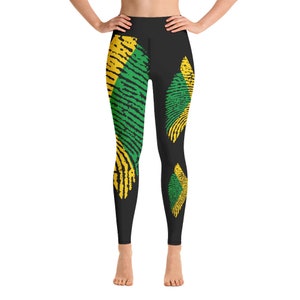 Könnte beinhalten: Schwarze Leggings mit hoher Taille und einem Grafikdruck aus gelben und grünen Fingerabdruckmustern. Das Design umfasst ein großes vertikales Fingerabdruckmotiv auf dem linken Bein und zwei kleinere, separate Fingerabdruckformen rechts.