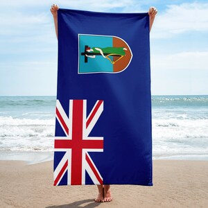 May include: A beach towel featuring the flag of the British Virgin Islands. The flag is blue with a white Union Jack in the lower left corner and a coat of arms in the upper left corner. The coat of arms features a woman lying on a cross with a harp.