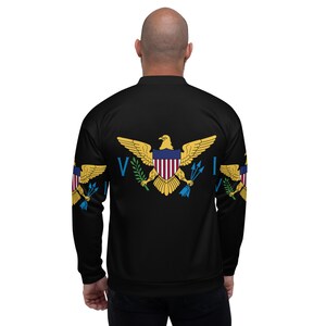 May include: A black bomber jacket with a full-colour print of the Virgin Islands flag on the back. The flag features a golden eagle with a red, white and blue shield, green leaves, and blue tridents.