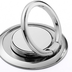 May include: A silver phone ring holder with a circular base and a 360-degree rotating ring. The ring is designed to be used as a stand for a phone.