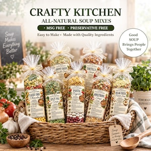 May include: A woven basket containing six clear plastic bags of Crafty Kitchen all-natural soup mixes, each tied with a gold ribbon. The labels feature text including Classic Corn Chowder, Split Pea Soup, Pasta Fagioli, Minestrone, and Cream Cheese Potato Soup.