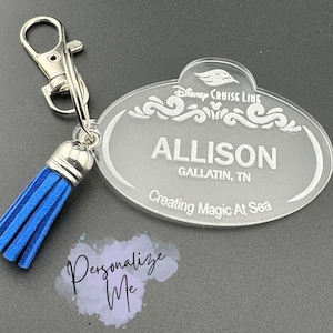 May include: A clear acrylic Disney Cruise Line name tag keychain with a blue tassel. The name tag says "Allison, Gallatin, TN, Creating Magic At Sea."