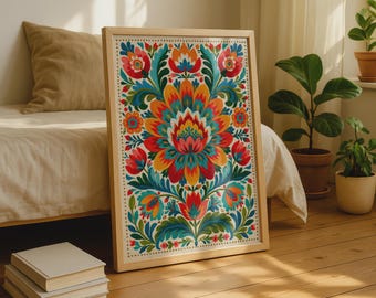 May include: A rectangular framed print featuring a vibrant folk art floral pattern with symmetrical red, orange, yellow, and teal petals and green leaves. The artwork is enclosed in a light-colored wooden frame with a simple, clean border design.