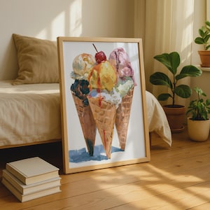 Op de afbeelding: Een ingelijste kunstdruk met een olieverfschilderij van drie ijshoorntjes met wafelpatroon. De hoorntjes zijn gevuld met bollen geel, roze, wit en donkerbruin ijs, met een enkele rode kers bovenop de middelste gele bol.