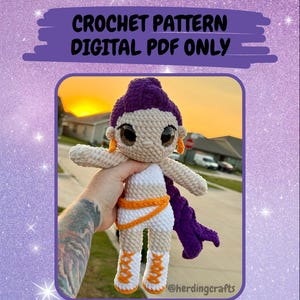 Op de afbeelding: Een handgemaakte gehaakte pop genaamd Yumi, met een paarse hoofdbedekking en vlecht. De pop heeft grote ogen, oranje oorbellen en een witte en oranje outfit. De tekst "CROCHET PATTERN DIGITAL PDF ONLY" en "Yumi - The Vocals" is ook zichtbaar.