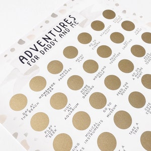 May include: A white card with gold circles and black text. The card has the title "Adventures for Daddy and Me" and lists activities like "Make Pancakes", "Visit an Aquarium", "Go to the Cinema", and "Feed the Ducks".