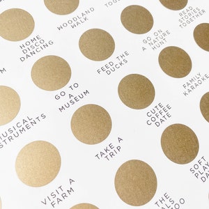 May include: A gold-colored chart with a list of activities to do with family and friends. The chart is divided into circles with text inside each circle. Some of the activities include "Go to a Museum", "Feed the Ducks", "Take a Trip", "Visit a Farm", "See the Animals at the Zoo", "Cute Coffee Date", "Family Karaoke", "Soft Play Date", "Read Stories Together", "Go on a Nature Hunt", "Paint Together", "Get Crafting", "Messy Play", "Home Disco Dancing", "Woodland Walk", and "Musical Instruments".