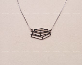 May include: A silver necklace with a stack of three books charm. The charm is a simple outline of the books.