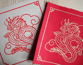 May include: Two square cards with a red dragon design. One card has a red dragon on a white background with a red border. The other card has a gold dragon on a red background with a gold border.