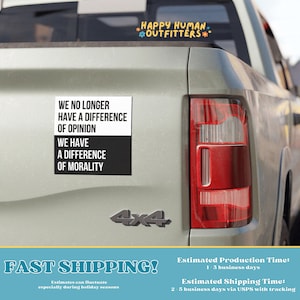 May include: A white sticker on a gray truck bed with black text that reads "We no longer have a difference of opinion. We have a difference of morality." The sticker is below a smaller sticker that reads "Happy Human Outfitters".