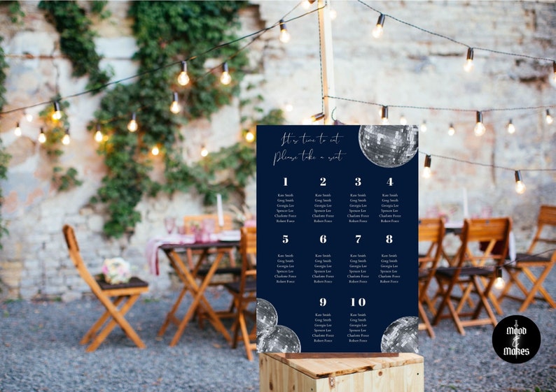 May include: A navy blue seating chart with silver glitter disco balls. The chart has the text "It's time to eat, Please take a seat." and lists table numbers 1 through 10 with guest names.