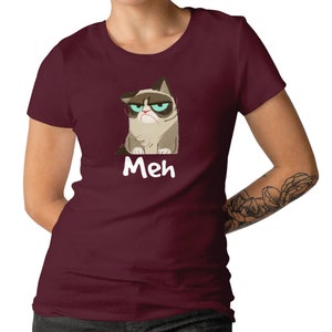 May include: A maroon t-shirt featuring a cartoon image of a grumpy cat and the word "Meh" printed on the front.