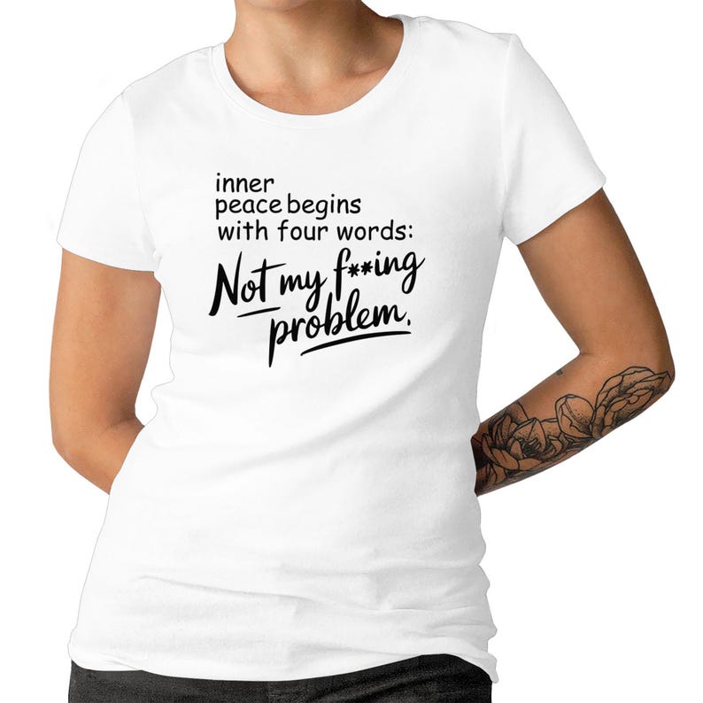 Op de afbeelding: Wit T-shirt met zwarte tekst die luidt: "inner peace begins with four words: Not my f***ing problem."