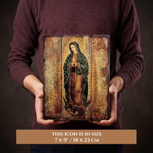 Pode incluir: &Iacute;cone religioso com a imagem da Virgem Maria, com um halo dourado e um manto verde escuro. O &iacute;cone tem 18 x 23 cm e &eacute; apresentado num painel de madeira com um acabamento envelhecido.