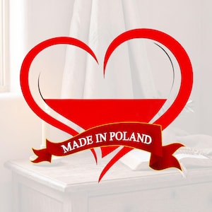 Pode incluir: Gr&aacute;fico vermelho em forma de cora&ccedil;&atilde;o com um design com as cores da bandeira polonesa. Uma faixa vermelha com o texto "MADE IN POLAND" em branco est&aacute; abaixo do cora&ccedil;&atilde;o. A imagem tem um fundo suave e desfocado.