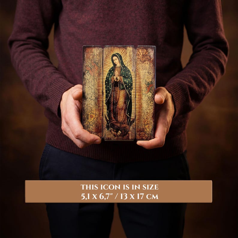 Pode incluir: &Iacute;cone religioso retratando uma figura em vestes e v&eacute;u escuros, com aur&eacute;ola, segurado por uma pessoa. O &iacute;cone mede 13 x 17 cm. O fundo tem uma apar&ecirc;ncia vintage e envelhecida com um brilho dourado.