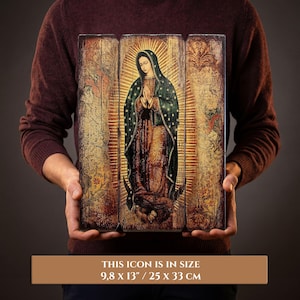 Pode incluir: &Iacute;cone religioso retratando uma figura com um manto verde escuro e aur&eacute;ola dourada, com as m&atilde;os juntas em ora&ccedil;&atilde;o. O &iacute;cone &eacute; apresentado em tr&ecirc;s pain&eacute;is de madeira com aspecto envelhecido. O texto na parte inferior diz: ESTE &Iacute;CONE TEM O TAMANHO 25 x 33 cm.