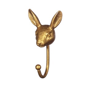 May include: Gold rabbit head coat hook. The hook is shaped like a rabbit's head with a curved hook extending from the bottom.