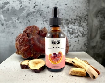 May include: A brown glass bottle with a dropper, labelled "Brother Birch Mushroom Reishi Immune Support + Stress Relief" with a red and white mushroom illustration. The bottle is sitting on a light grey surface with dried mushrooms.