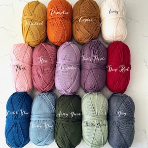May include: A collection of 15 yarn balls in various colors, including pink, lavender, dusty purple, deep red, army green, dusty green, grey, ivory, mustard, pumpkin, cognac, rose, cadet blue, and dusty blue.