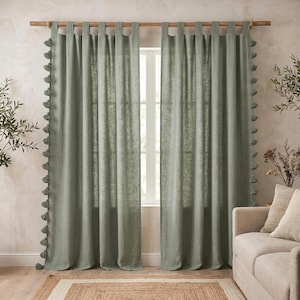 Peut inclure: Une paire de rideaux vert sauge dotés d'un système de fixation à pattes pour une tringle en bois. Les bords verticaux des rideaux sont ornés d'une série de pompons assortis de couleur vert sauge, disposés du haut vers le bas de chaque panneau.