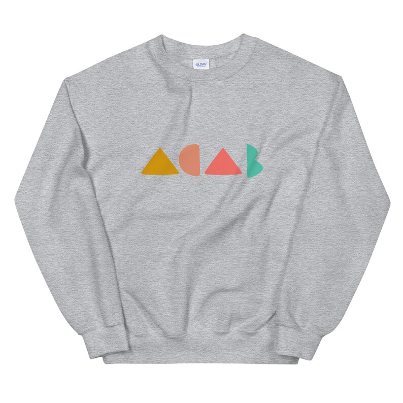 K&ouml;nnte beinhalten: Ein hellgraues Sweatshirt mit dem Wort "ACAB" in bunten geometrischen Formen. Die Buchstaben sind in Orange, Pfirsich, Koralle und T&uuml;rkis gehalten. Das Sweatshirt ist aus einem weichen Material.