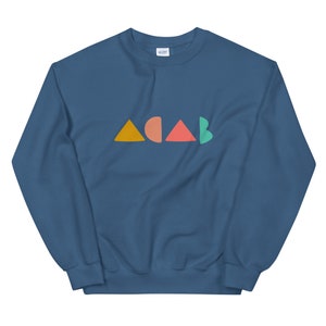 K&ouml;nnte beinhalten: Ein marineblaues Sweatshirt mit dem Wort "ACAB" in bunten geometrischen Formen. Die Buchstaben sind orange, korallenrot, rot und gr&uuml;n. Das Sweatshirt besteht aus einem weichen Material.