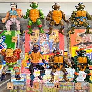 May include: A set of three ceramic mugs with a speckled, matte finish. The mugs are in shades of cream, light gray, and dark gray. Each mug has a simple, minimalist design, perfect for coffee or tea.