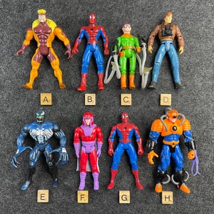 Selection of loose 1990s Toy Biz Spiderman and X Men action figures arranged on gray background with lettered markers