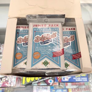 May include: A box of 1991 Upper Deck Major League Baseball Jumbo Packs. Each pack features a blue and white design with the words "Baseball" and "1991 Edition". The packs are sealed in clear plastic.