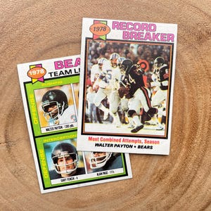 May include: Two vintage 1978 football trading cards featuring Walter Payton. The top card is a "Record Breaker" card with a photo of Payton running with the football. The bottom card is a "Team Leader" card with a photo of Payton in a defensive stance. Both cards feature the Chicago Bears logo.