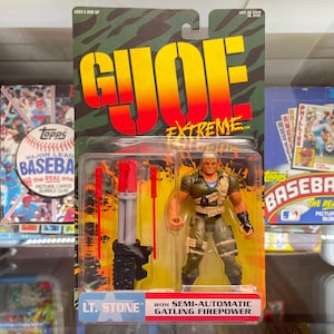 May include: G.I. Joe Extreme action figure of Lt. Stone, packaged on a green and camouflage card. The figure is in a military uniform and comes with a semi-automatic Gatling Firepower weapon. The packaging includes the text "Ages 5 and Up."