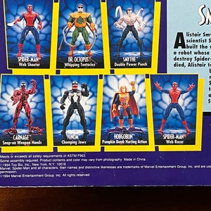 May include: A collection of Spider-Man action figures, including Spider-Man, Carnage, Venom, Hobgoblin, Dr. Octopus, and Smythe. The figures are posed in action poses and have various accessories. The packaging features a blue and yellow background with the Spider-Man logo and the text "Smythe".