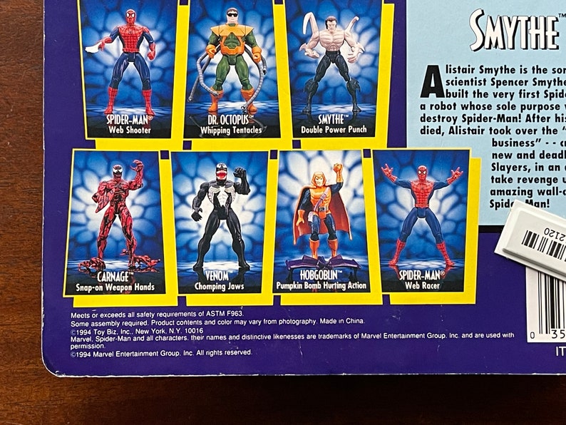 May include: A collection of Spider-Man action figures, including Spider-Man, Carnage, Venom, Hobgoblin, Dr. Octopus, and Smythe. The figures are posed in action poses and have various accessories. The packaging features a blue and yellow background with the Spider-Man logo and the text "Smythe".