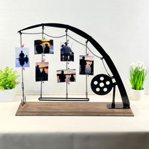 display photos hanging from an old fishing pole Exclusive Rifle or Rod Frame painted poly We had some old windows