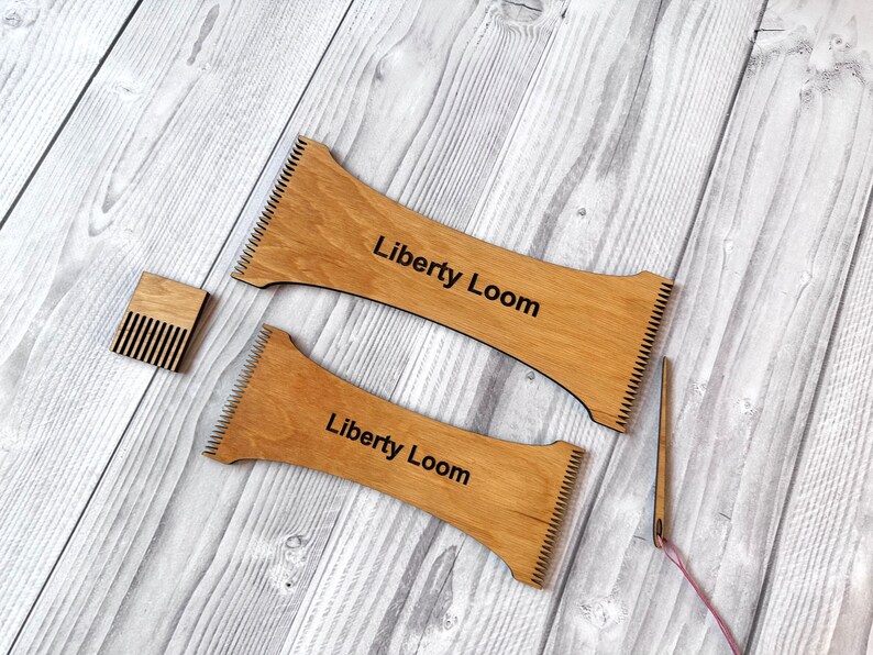 May include: Two wooden weaving looms with the text "Liberty Loom" printed on them. A small wooden comb and a pink yarn needle are also included.